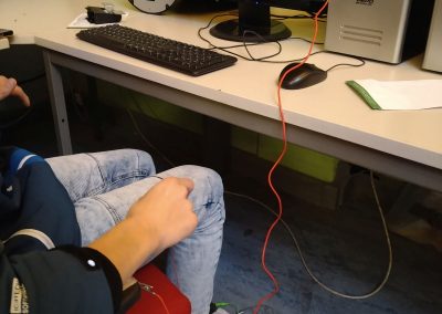 Ein Jugendlicher sitzt in einem Stuhl und steuert ein Computerspiel